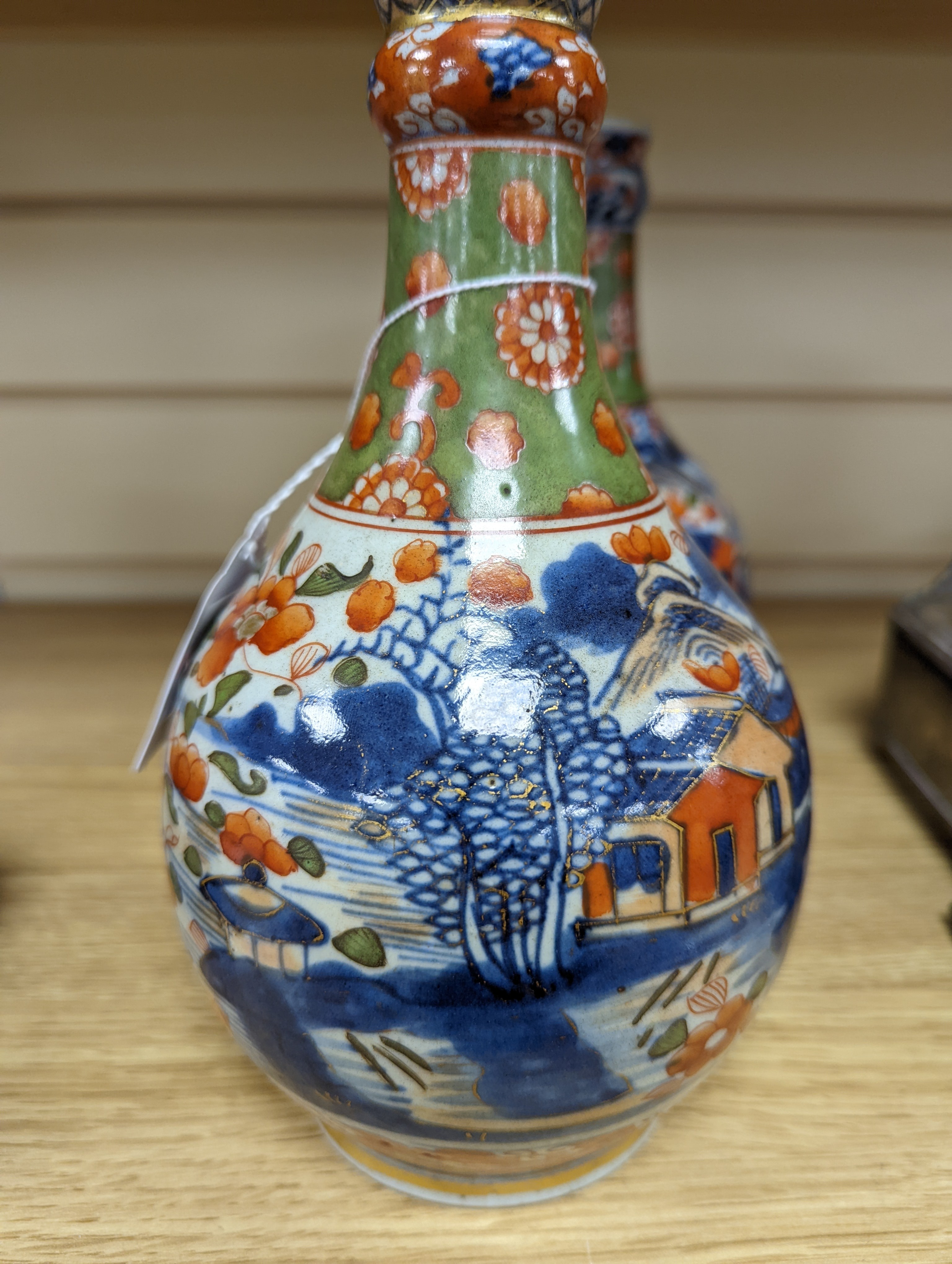 A pair of 18th century Chinese clobbered blue and white bottle vases 23cm